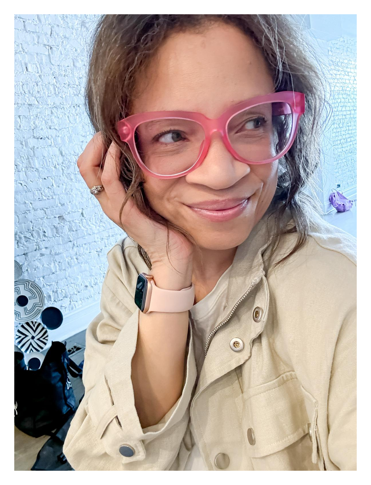 Ronni in a brown jacket with pink glasses